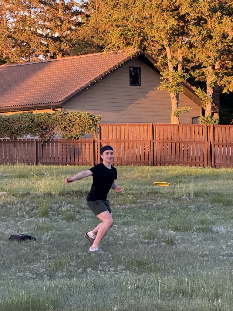 The stance that started it all — a disc golfer mid-throw at golden hour on a Saskatchewan course